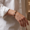 Woman wearing the Coral Reef Baltic Amber Bracelet in Sterling Silver, showcasing genuine Baltic amber and polished 925 sterling silver in an elegant luxury jewelry lifestyle setting.