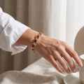 Woman wearing the Lottie Baltic Honey Amber Bracelet in Sterling Silver, showcasing genuine honey Baltic amber and polished 925 sterling silver in an elegant luxury jewelry lifestyle setting.