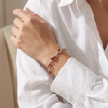 Woman wearing the GIA Certified Baltic Honey Amber Bracelet in Sterling Silver, showcasing genuine honey Baltic amber and polished 925 sterling silver in an elegant luxury jewelry lifestyle setting.