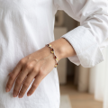 Woman wearing the Baltic Honey Amber Bracelet in Sterling Silver, showcasing genuine honey Baltic amber and polished 925 sterling silver in an elegant luxury jewelry lifestyle setting.