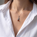 Woman wearing the Rose Baltic Amber Pendant in Sterling Silver, showcasing genuine Baltic amber and polished 925 sterling silver in an elegant luxury jewelry lifestyle setting.