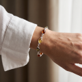 Woman wearing the Agnes Multicolor Baltic Amber Bracelet in Sterling Silver, showcasing genuine multicolor Baltic amber and polished 925 sterling silver in an elegant luxury jewelry lifestyle setting.