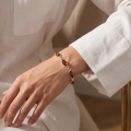 Woman wearing the Sunny Baltic Honey Amber Bracelet in Sterling Silver, showcasing genuine honey Baltic amber and polished 925 sterling silver in an elegant luxury jewelry lifestyle setting.