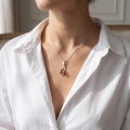 Woman wearing the Dolphins Baltic Honey Amber Necklace in Sterling Silver, showcasing genuine honey Baltic amber and polished 925 sterling silver in an elegant luxury jewelry lifestyle setting.