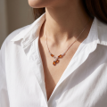 Woman wearing the Julianne Baltic Honey Amber Necklace in Sterling Silver, showcasing genuine honey Baltic amber and polished 925 sterling silver in an elegant luxury jewelry lifestyle setting.