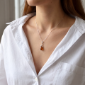 Woman wearing the Tina Baltic Amber Pendant in Sterling Silver, showcasing genuine Baltic amber and polished 925 sterling silver in an elegant luxury jewelry lifestyle setting.
