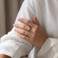Woman wearing the Infinity Baltic Honey Amber Ring in Sterling Silver, showcasing genuine honey Baltic amber and polished 925 sterling silver in an elegant luxury jewelry lifestyle setting.