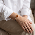 Woman wearing the Baltic Honey Amber Adjustable Bracelet in Sterling Silver, showcasing genuine honey Baltic amber and polished 925 sterling silver in an elegant luxury jewelry lifestyle setting.