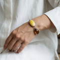 Woman wearing the Baltic Honey Amber Adjustable Bracelet in Sterling Silver, showcasing genuine honey Baltic amber and polished 925 sterling silver in an elegant luxury jewelry lifestyle setting.