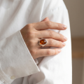 Woman wearing the Aine Baltic Honey Amber Oval Ring in Sterling Silver, showcasing genuine honey Baltic amber and polished 925 sterling silver in an elegant luxury jewelry lifestyle setting.
