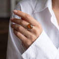 Woman wearing the Alaina Baltic Honey Amber Ring in Sterling Silver, showcasing genuine honey Baltic amber and polished 925 sterling silver in an elegant luxury jewelry lifestyle setting.