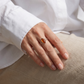 Woman wearing the Alani Baltic Honey Amber Ring in Sterling Silver, showcasing genuine honey Baltic amber and polished 925 sterling silver in an elegant luxury jewelry lifestyle setting.