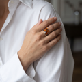 Woman wearing the Astrid Baltic Honey Amber Ring in Sterling Silver, showcasing genuine honey Baltic amber and polished 925 sterling silver in an elegant luxury jewelry lifestyle setting.
