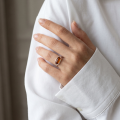 Woman wearing the Claire Baltic Honey Amber Ring in Sterling Silver, showcasing genuine honey Baltic amber and polished 925 sterling silver in an elegant luxury jewelry lifestyle setting.