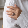 Woman wearing the Gaelle Baltic Honey Amber Ring in Sterling Silver, showcasing genuine honey Baltic amber and polished 925 sterling silver in an elegant luxury jewelry lifestyle setting.