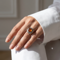 Woman wearing the Inga Baltic Honey Amber Round Ring in Sterling Silver, showcasing genuine honey Baltic amber and polished 925 sterling silver in an elegant luxury jewelry lifestyle setting.