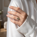 Woman wearing the Joan Baltic Green Amber Ring in Sterling Silver, showcasing genuine green Baltic amber and polished 925 sterling silver in an elegant luxury jewelry lifestyle setting.