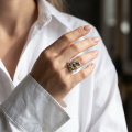 Woman wearing the Layla Baltic Green Amber Ring in Sterling Silver, showcasing genuine green Baltic amber and polished 925 sterling silver in an elegant luxury jewelry lifestyle setting.