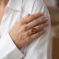 Woman wearing the Lois Baltic Honey Amber Ring in Sterling Silver, showcasing genuine honey Baltic amber and polished 925 sterling silver in an elegant luxury jewelry lifestyle setting.