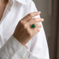 Woman wearing the Baltic Green Amber Adjustable Ring in Gold-Plated Sterling Silver, showcasing genuine green Baltic amber and polished gold-plated 925 sterling silver in an elegant luxury jewelry lifestyle setting.