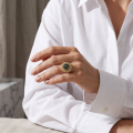 Woman wearing the Baltic Green Amber Sunflower Ring in Gold-Plated Sterling Silver, showcasing genuine green Baltic amber and polished gold-plated 925 sterling silver in an elegant luxury jewelry lifestyle setting.