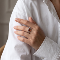 Woman wearing the Baltic Honey Amber Celtic Knot Ring in Sterling Silver, showcasing genuine honey Baltic amber and polished 925 sterling silver in an elegant luxury jewelry lifestyle setting.