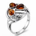 Baltic Honey Amber Infinity Ring in Sterling Silver featuring genuine honey Baltic amber set in a polished 925 sterling silver infinity design, isolated on a white background.Baltic Honey Amber Infinity Ring in Sterling Silver featuring genuine honey Baltic amber set in a polished 925 sterling silver infinity design, isolated on a white background.