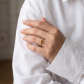 Woman wearing the Baltic Honey Amber Ring in Gold-Plated Sterling Silver, showcasing genuine honey Baltic amber and polished gold-plated 925 sterling silver in an elegant luxury jewelry lifestyle setting.