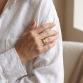 Woman wearing the Celtic Knots Baltic Butterscotch Amber Ring in Sterling Silver, showcasing genuine butterscotch Baltic amber and polished 925 sterling silver in an elegant luxury jewelry lifestyle setting.