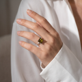Woman wearing the GIA Certified Nelda Baltic Green Amber Square Ring in Sterling Silver, showcasing genuine green Baltic amber and polished 925 sterling silver in an elegant luxury jewelry lifestyle setting.