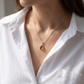 Woman wearing the Ana Baltic Honey Amber Oval Pendant in Sterling Silver, showcasing genuine honey Baltic amber and polished 925 sterling silver in an elegant luxury jewelry lifestyle setting.