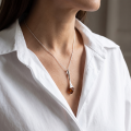 Woman wearing the Baltic Honey Amber Pendant in Sterling Silver, showcasing genuine honey Baltic amber and polished 925 sterling silver in an elegant luxury jewelry lifestyle setting.