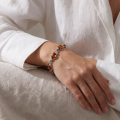 Woman wearing the Willow Baltic Honey Amber Bracelet in Sterling Silver, showcasing genuine honey Baltic amber gemstones and polished 925 sterling silver in an elegant luxury jewelry lifestyle setting.