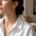 Woman wearing the Alessia Baltic Honey Amber Stud Earrings in Sterling Silver, showcasing genuine honey Baltic amber gemstones and polished 925 sterling silver in an elegant luxury jewelry lifestyle setting.