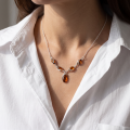 Woman wearing the Gemma Baltic Honey Amber Necklace in Sterling Silver, showcasing genuine honey Baltic amber and polished 925 sterling silver in an elegant luxury jewelry lifestyle setting.
