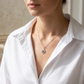 Woman wearing the Snowflake Baltic Amber Pendant in Sterling Silver, showcasing genuine Baltic amber and polished 925 sterling silver in an elegant luxury jewelry lifestyle setting.