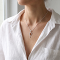 Woman wearing the Baltic Honey Amber Angel Pendant in Sterling Silver, showcasing genuine honey Baltic amber and polished 925 sterling silver in an elegant luxury jewelry lifestyle setting.