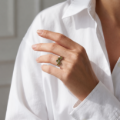 Woman wearing the Aria Baltic Green Amber Ring in Sterling Silver, showcasing genuine green Baltic amber and polished 925 sterling silver in an elegant luxury jewelry lifestyle setting.