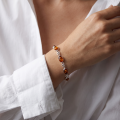 Woman wearing the Monique Baltic Honey Amber Bracelet in Sterling Silver, showcasing genuine honey Baltic amber gemstones and polished 925 sterling silver in an elegant luxury jewelry lifestyle setting.