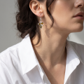 Woman wearing the Martina Baltic Green Amber Earrings in Sterling Silver, showcasing genuine green Baltic amber gemstones and polished 925 sterling silver in an elegant luxury jewelry lifestyle setting.
