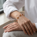 Woman wearing the Zuzanna Baltic Honey Amber Bracelet in Sterling Silver, showcasing genuine honey Baltic amber gemstones and polished 925 sterling silver in an elegant luxury jewelry lifestyle setting.