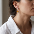 Close-up of a model wearing a “Kelly” Baltic Honey Amber earring in sterling silver.