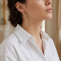 Close-up of a model wearing a “Hearts” Baltic Honey Amber Drop Earring.