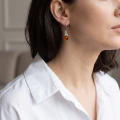 Close-up of a model wearing a “Melanie” Baltic Honey Amber Round Drop Earring.