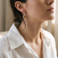 Close-up of a model wearing a Baltic Honey Amber Round Drop Earring in Sterling Silver.