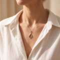 Close-up of a model wearing the “Freya” Baltic Honey Amber Pendant in Sterling Silver.
