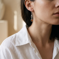 Close-up of a model wearing an “Amalie” Baltic Honey Amber Drop Earring.