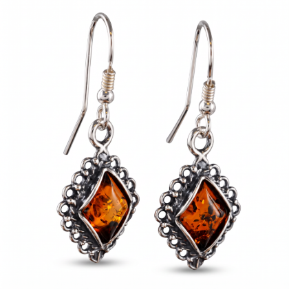 Pair of “Meryl” Baltic Honey Amber Earrings in Sterling Silver on a white background, featuring oval amber stones and ornate silver settings.