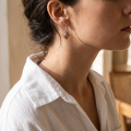 “Meryl” Baltic Honey Amber Earrings in Sterling Silver worn on a model, shown in a close-up side view.