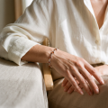 “Laura” Baltic Honey Amber Bracelet in Sterling Silver worn on a model’s wrist, shown in a close-up view.